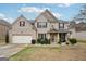 Charming two-story brick home boasts a two-car garage, manicured lawn, and inviting front porch at 3225 Alhambra Cir, Hampton, GA 30228