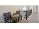 Upstairs hallway with sitting area featuring two chairs, a small table, and wood railing overlooking the stairs at 3225 Alhambra Cir, Hampton, GA 30228