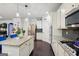 Bright kitchen with granite countertops, stainless appliances, and a kitchen island with bar seating and dark hardwood floors at 3225 Alhambra Cir, Hampton, GA 30228