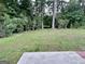 Spacious backyard with lush trees, and concrete patio at 581 N Fairfield Dr, Peachtree City, GA 30269