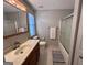 Bright bathroom with vanity, a large mirror, and shower-tub combo with a sliding glass door at 581 N Fairfield Dr, Peachtree City, GA 30269