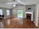 Bright living room with wood floors, a ceiling fan, fireplace, and sliding door accessing the backyard at 581 N Fairfield Dr, Peachtree City, GA 30269