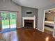 Cozy living room featuring wood floors, a brick fireplace, and sliding glass doors to the backyard at 581 N Fairfield Dr, Peachtree City, GA 30269