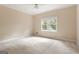 Empty bedroom with neutral walls, neutral carpet, one window, and white trim at 450 Riverwalk, Mcdonough, GA 30252