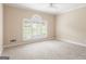 Bright bedroom with neutral walls, carpet, a ceiling fan, and a large window at 450 Riverwalk, Mcdonough, GA 30252