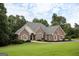 Traditional brick home boasts a pristine lawn, mature trees, and elegant architectural details at 450 Riverwalk, Mcdonough, GA 30252