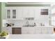 Traditional kitchen featuring white cabinetry, gold hardware, stainless steel appliances, and tile backsplash at 450 Riverwalk, Mcdonough, GA 30252