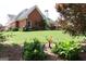 Scenic backyard view featuring a lush lawn and beautiful garden with vibrant green foliage and flowers at 405 Mallory Cir, Loganville, GA 30052