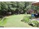 Expansive backyard featuring lush green grass, mature trees, an outdoor grill, and a relaxing seating area with comfortable chairs at 405 Mallory Cir, Loganville, GA 30052