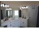 A dual-sink bathroom has vanity storage, great lighting, and separate bath at 405 Mallory Cir, Loganville, GA 30052