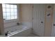 A relaxing bathroom features a jetted tub next to a window for natural light at 405 Mallory Cir, Loganville, GA 30052