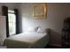 Bright bedroom boasts a comfortable bed with patterned pillows, complemented by neutral gray walls and a large window at 405 Mallory Cir, Loganville, GA 30052