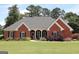 Charming red brick home with a well-manicured lawn and mature landscaping at 405 Mallory Cir, Loganville, GA 30052
