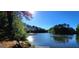 Scenic lake view with a bench on the shore surrounded by mature trees on a clear day at 405 Mallory Cir, Loganville, GA 30052