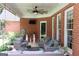 Covered patio with brick walls, comfortable seating, a ceiling fan, and a view of the garden at 405 Mallory Cir, Loganville, GA 30052