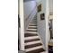 View of the carpeted staircase with wooden handrail, ascending to the upper level of the home at 405 Mallory Cir, Loganville, GA 30052