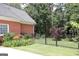 Manicured yard with lush green grass, a black metal fence, and a variety of vibrant flowers and plants, creating curb appeal at 405 Mallory Cir, Loganville, GA 30052