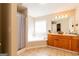 Bright bathroom with large soaking tub, wood cabinets, and tiled floors at 2545 Lake Royale Dr, Riverdale, GA 30296