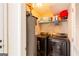 Functional laundry room with washer, dryer, and storage shelves at 2545 Lake Royale Dr, Riverdale, GA 30296