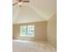 Bright bedroom featuring a ceiling fan, vaulted ceilings, and a large window with lush views at 500 Barrington Farms Pkwy, Sharpsburg, GA 30277