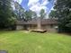 This home features a large, grassy backyard with a wooden deck, perfect for outdoor entertaining and relaxation at 56 Ridgewood Ct, Mcdonough, GA 30252