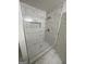 Modern tiled shower with hexagon tile base, built-in niche and white marble-look wall tiles at 56 Ridgewood Ct, Mcdonough, GA 30252