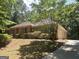 Brick ranch-style home featuring mature trees, a well-maintained lawn, and an inviting, extended driveway at 56 Ridgewood Ct, Mcdonough, GA 30252