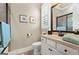 Bathroom with a framed mirror, white cabinets, and natural light from window at 406 Horizon Trl, Canton, GA 30114