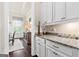 Butler's pantry with granite countertops, white cabinetry, and hardwood floors at 406 Horizon Trl, Canton, GA 30114