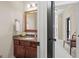 Bathroom vanity with wood cabinet, granite countertop, and bronze fixtures at 4595 Carriage Walk Ln, Cumming, GA 30040