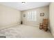 Spacious bedroom with neutral walls, carpet, white trim, and a rocking chair at 4595 Carriage Walk Ln, Cumming, GA 30040
