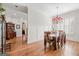 An elegant dining room with hardwood flooring, trim accents, and a decorative chandelier at 4595 Carriage Walk Ln, Cumming, GA 30040