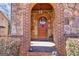 A gorgeous solid wood arched front door with brick and stone entryway at 4595 Carriage Walk Ln, Cumming, GA 30040