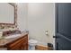 Tastefully designed powder room featuring granite countertops and a decorative mirror at 4595 Carriage Walk Ln, Cumming, GA 30040