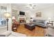 Cozy living room with hardwood floors, fireplace, and built-in shelving at 4595 Carriage Walk Ln, Cumming, GA 30040