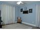 Neutral-toned bedroom with a side chair, large window with white drapes, and hardwood flooring at 219 Brown Branch Rd, Locust Grove, GA 30248