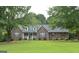 Charming one-story brick home featuring a well-manicured lawn and complemented by lush, mature trees at 219 Brown Branch Rd, Locust Grove, GA 30248