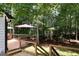 Outdoor deck featuring dining and lounging areas, along with a view of the wooded backyard at 85 Pine Haven Dr, Carrollton, GA 30116