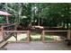 Multi-level wooden deck with seating areas and staircase, overlooking a lush wooded backyard at 85 Pine Haven Dr, Carrollton, GA 30116