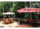 Outdoor deck featuring seating, umbrellas, a grill, and scenic views of the wooded backyard at 85 Pine Haven Dr, Carrollton, GA 30116