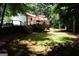 Beautiful backyard with large deck and stairs leading to a grassy lawn, surrounded by mature trees at 85 Pine Haven Dr, Carrollton, GA 30116