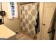 Bright bathroom featuring a decorative shower curtain, white cabinets, and natural light from the window at 85 Pine Haven Dr, Carrollton, GA 30116