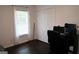 Cozy bedroom featuring dark wood floors, a window with blinds, and a functional workspace with computer at 85 Pine Haven Dr, Carrollton, GA 30116