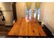 Dining area featuring a rustic wood table with views of the backyard, alongside a stainless steel refrigerator at 85 Pine Haven Dr, Carrollton, GA 30116