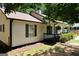 Quaint home showcasing a covered front porch with hanging plants and lush landscaping at 85 Pine Haven Dr, Carrollton, GA 30116