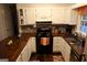 A well-equipped kitchen featuring wood countertops, white cabinets, stainless steel appliances and dark-stained hardwood floors at 85 Pine Haven Dr, Carrollton, GA 30116