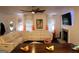 Bright living room featuring a white sectional couch, fireplace, and ceiling fan at 85 Pine Haven Dr, Carrollton, GA 30116
