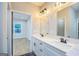 Bathroom with double sinks, white cabinets, quartz counters, and modern lighting at 809 Dill Sw Ave, Atlanta, GA 30310