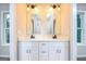 Bright bathroom with a double vanity, marble countertop, modern fixtures, and two mirrors at 809 Dill Sw Ave, Atlanta, GA 30310