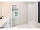 Well-lit bathroom featuring marble countertops, black hardware, and a view into the bedroom and shower at 809 Dill Sw Ave, Atlanta, GA 30310